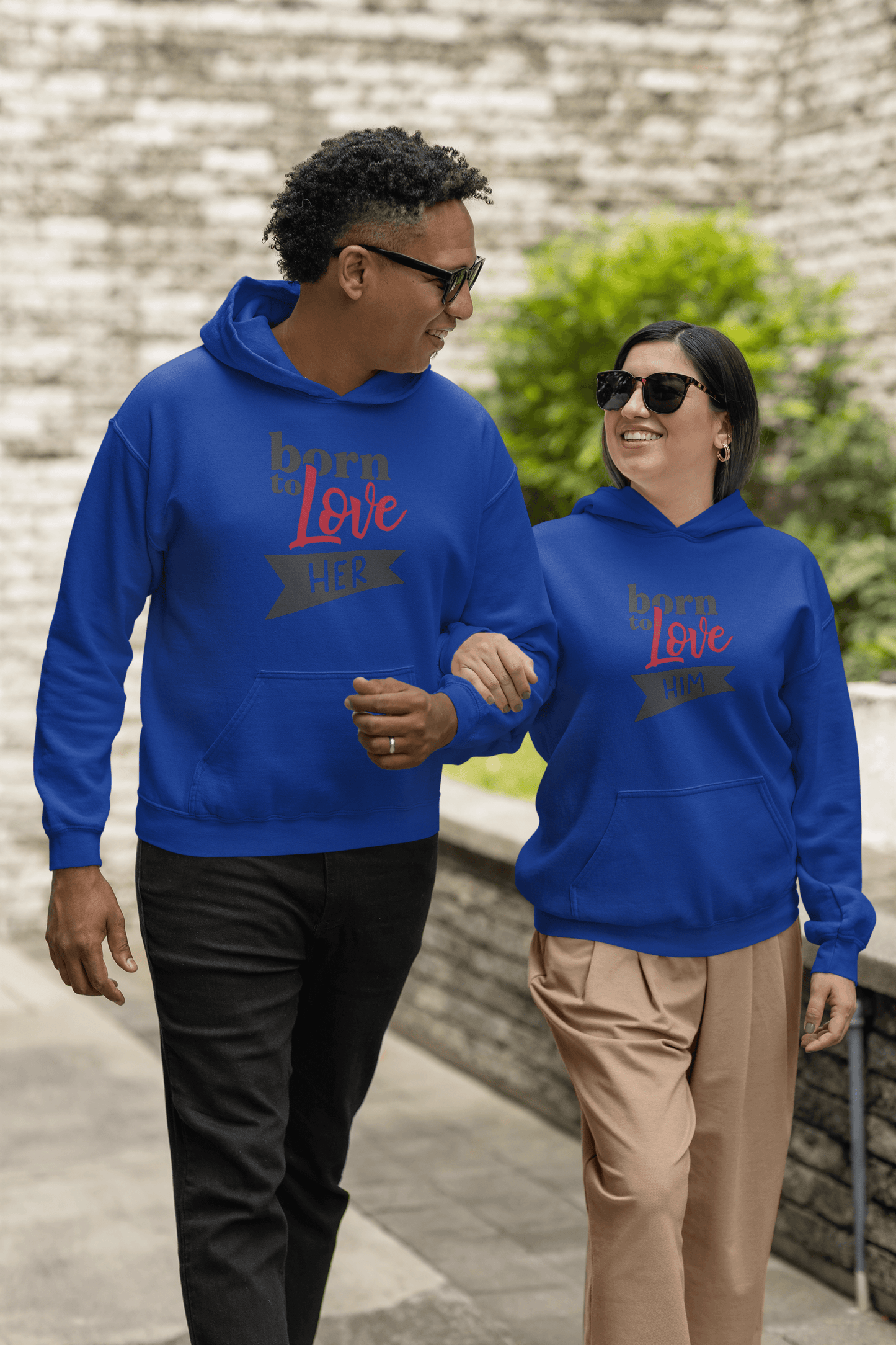 Couple walking in matching blue Born to Love hoodies, showcasing stylish comfort and elegance.