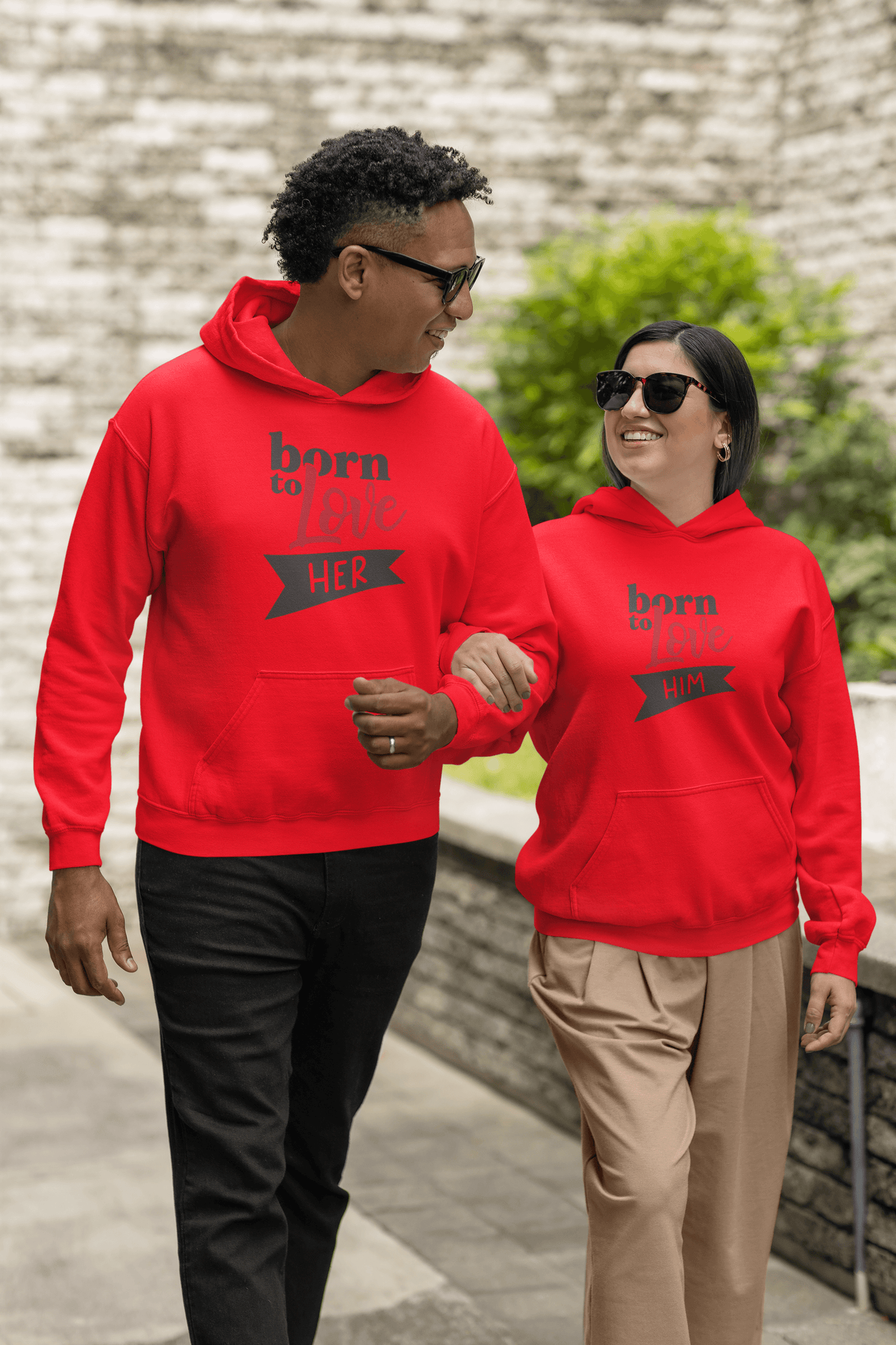 Couple wearing matching Born to Love Hoodies in red, showcasing stylish design and cozy comfort.